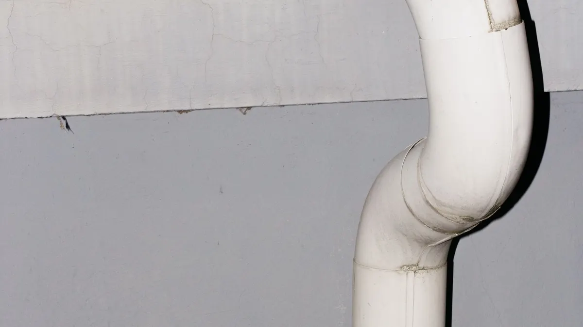 Bajante blanco de PVC instalado en la fachada de un edificio de viviendas